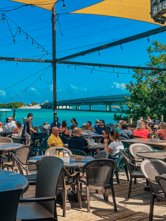 People eating at Hungry Tarpon Restaurant next to Ocean